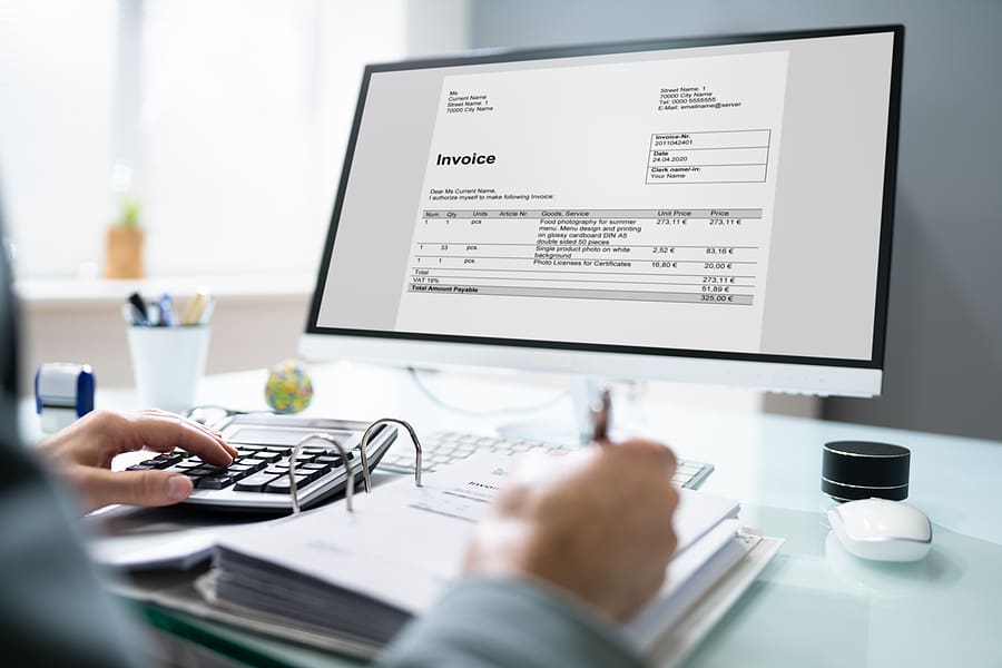 Close up of a computer screen with a professional using bookkeeping software for billing.