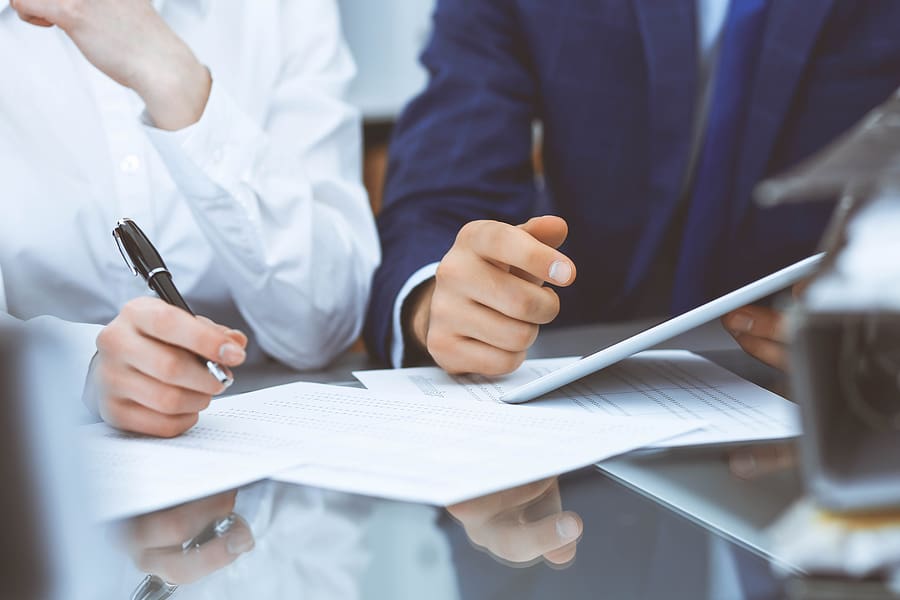 Close up of a man and woman sitting at a table looking over documents.